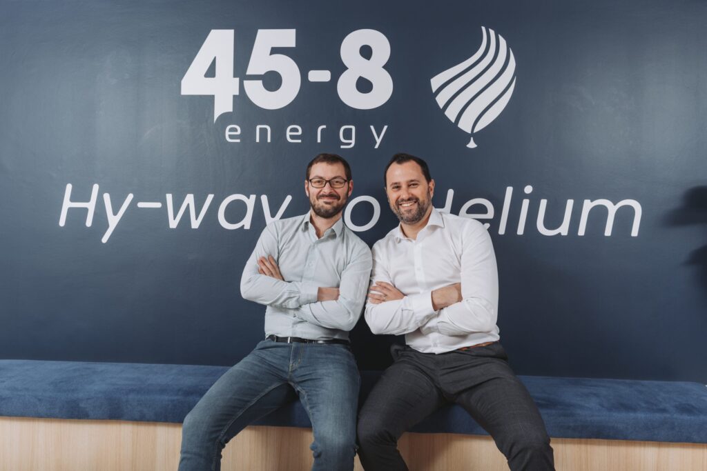 Deux fondateurs de 45-8 Energy, Benoît Heuville et Nicolas Pelissier, souriants, assis devant un mur avec le logo de leur entreprise et l'inscription "Hy-way to helium".
